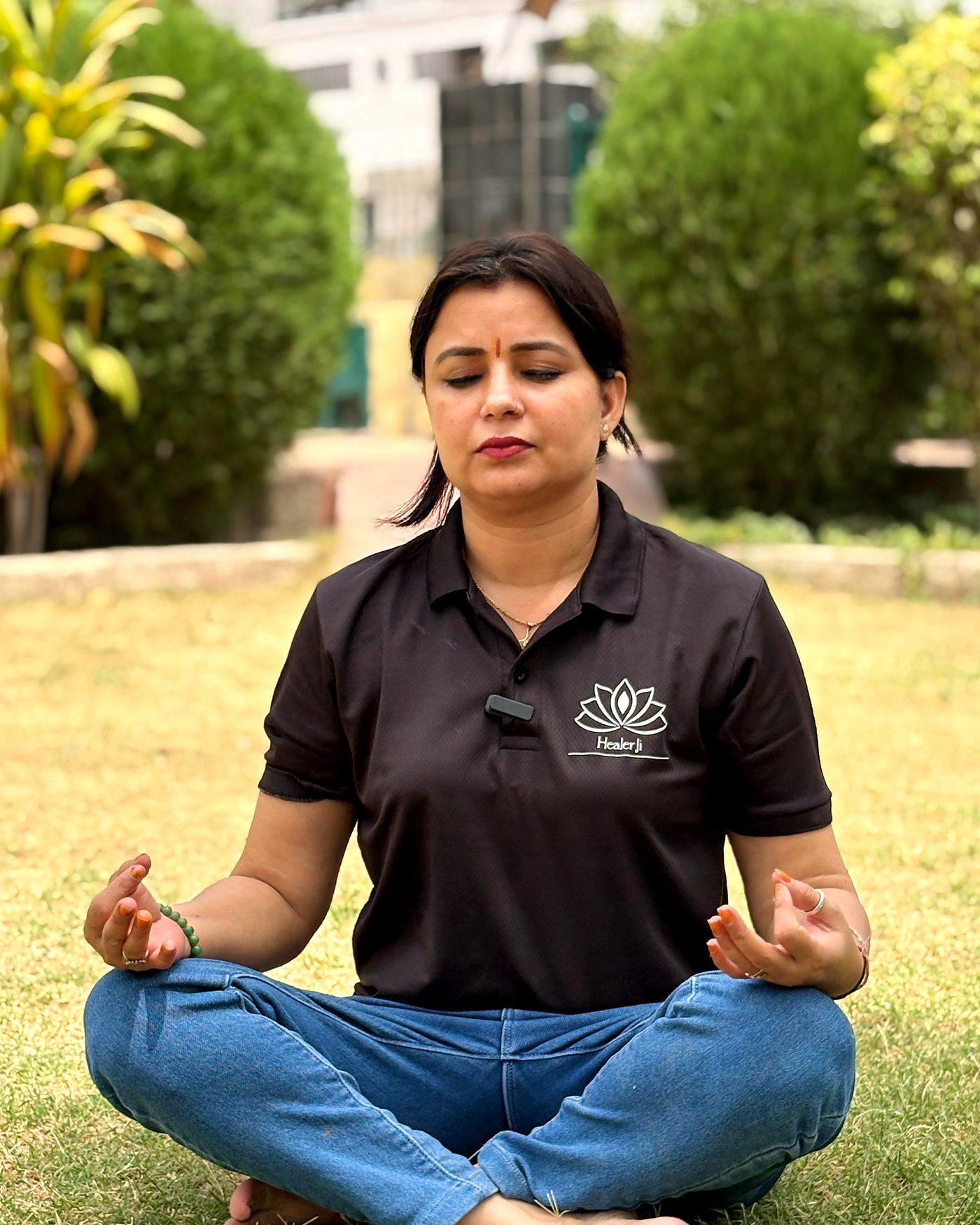 Dr. Poonam Khetan, founder of HealerJi, meditating cross-legged in a garden