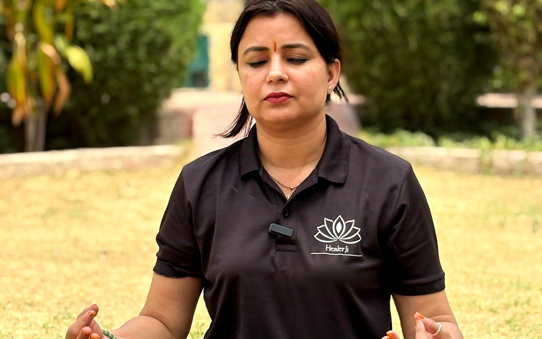 Dr. Poonam Khetan meditating in a garden, wearing a HealerJi shirt